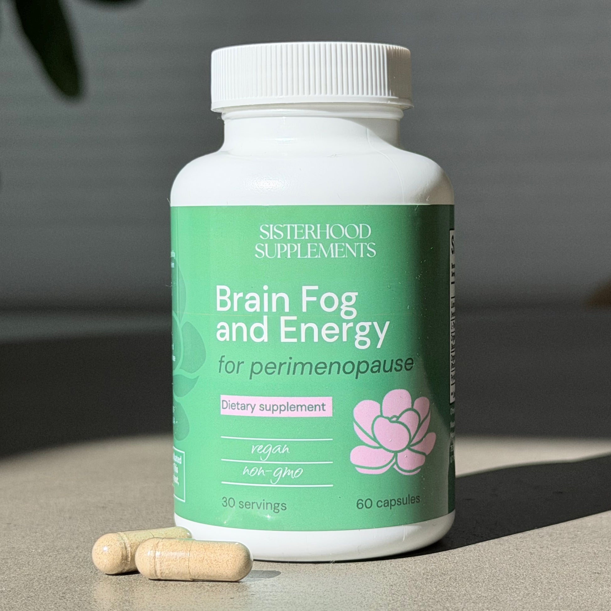 Supplement bottle labeled 'Brain Fog and Energy for perimenopause' by Sisterhood Supplements on a neutral background.